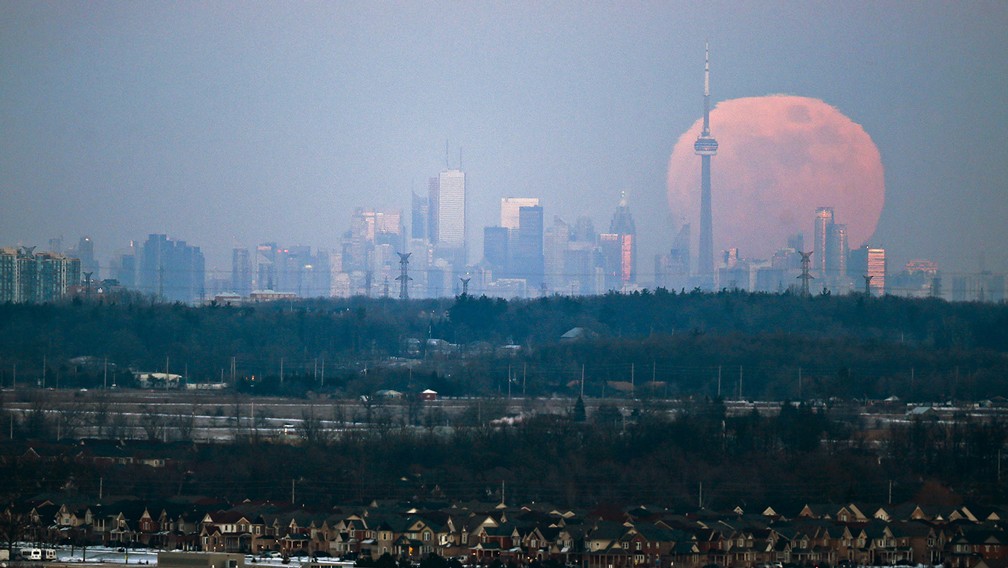 moon rises over the Toronto city skyline