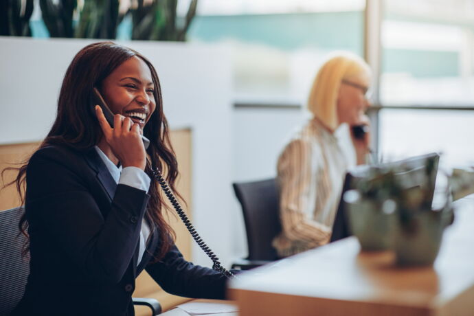 Woman smiling while talking on phone in office setting