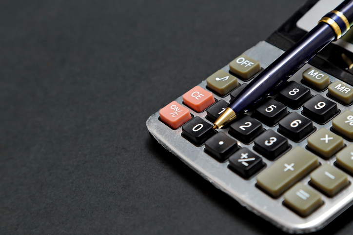 Closeup of a calculator against a dark gray background.