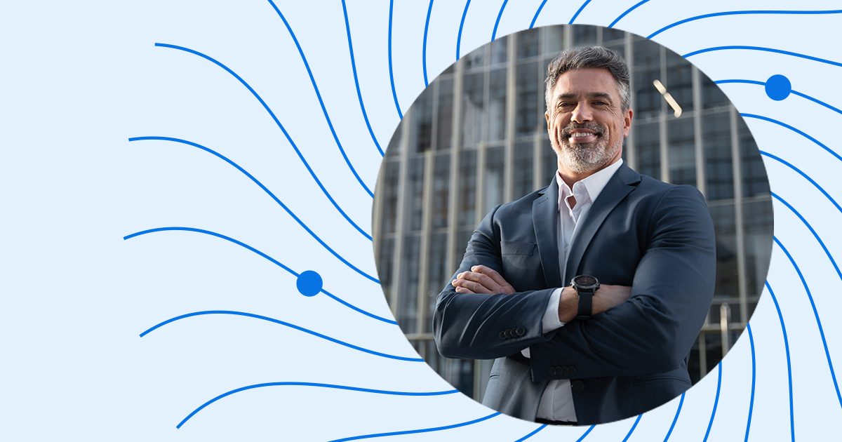 "Are you ready" campaign image. A businessman smiles at the camera with his arms folded.