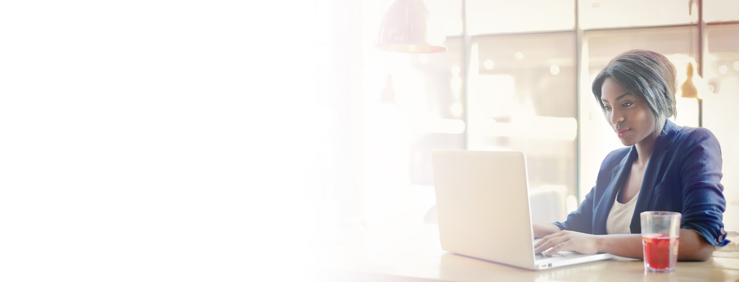 2880x1100 left white gradient of African American businesswoman working on a laptop.